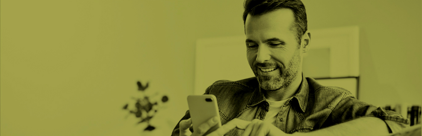 Hombre mayor sonriendo e interactuando con el celular