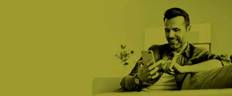 Hombre mayor sonriendo interactuando con celular