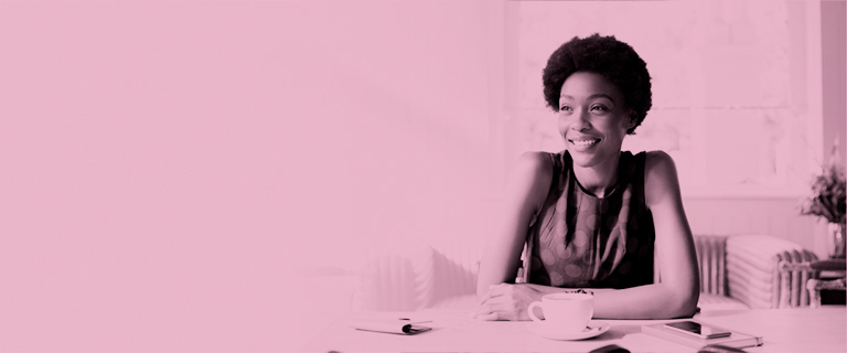 Mujer afro sentada en sofá sonriendo