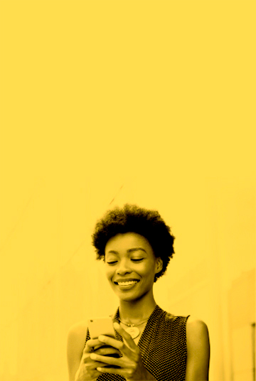 Mujer afro sonriendo utilizando celular