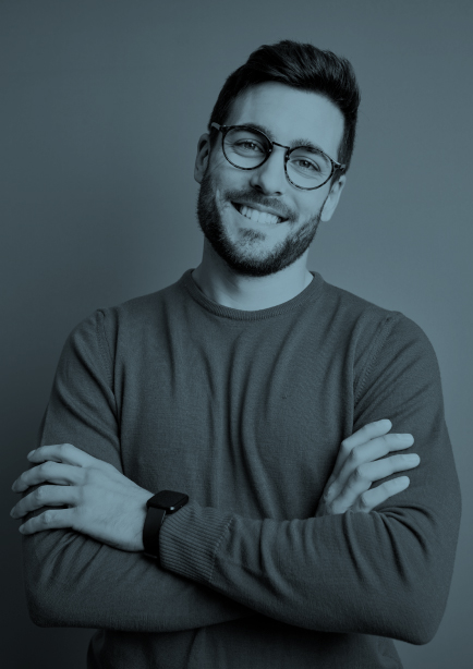 Hombre joven con barba y gafas alegre cruzando los brazos