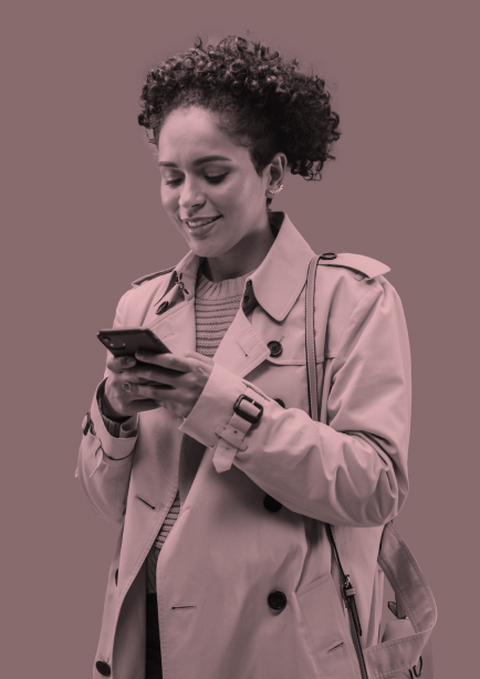 Mujer joven afro lee el celular en sus manos sonriendo