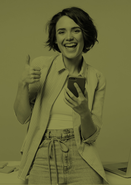 Mujer sentada en escritorio mientras levanta su pulgar con emoción