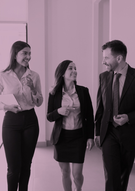 Dos mujeres y un hombre disfrutan hablando por la oficina