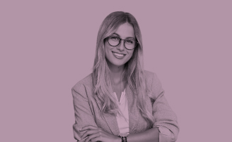 Mujer rubia ejecutiva con gafas sonríe cruzando los brazos