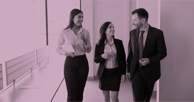 Dos mujeres y un hombre disfrutan hablando por la oficina